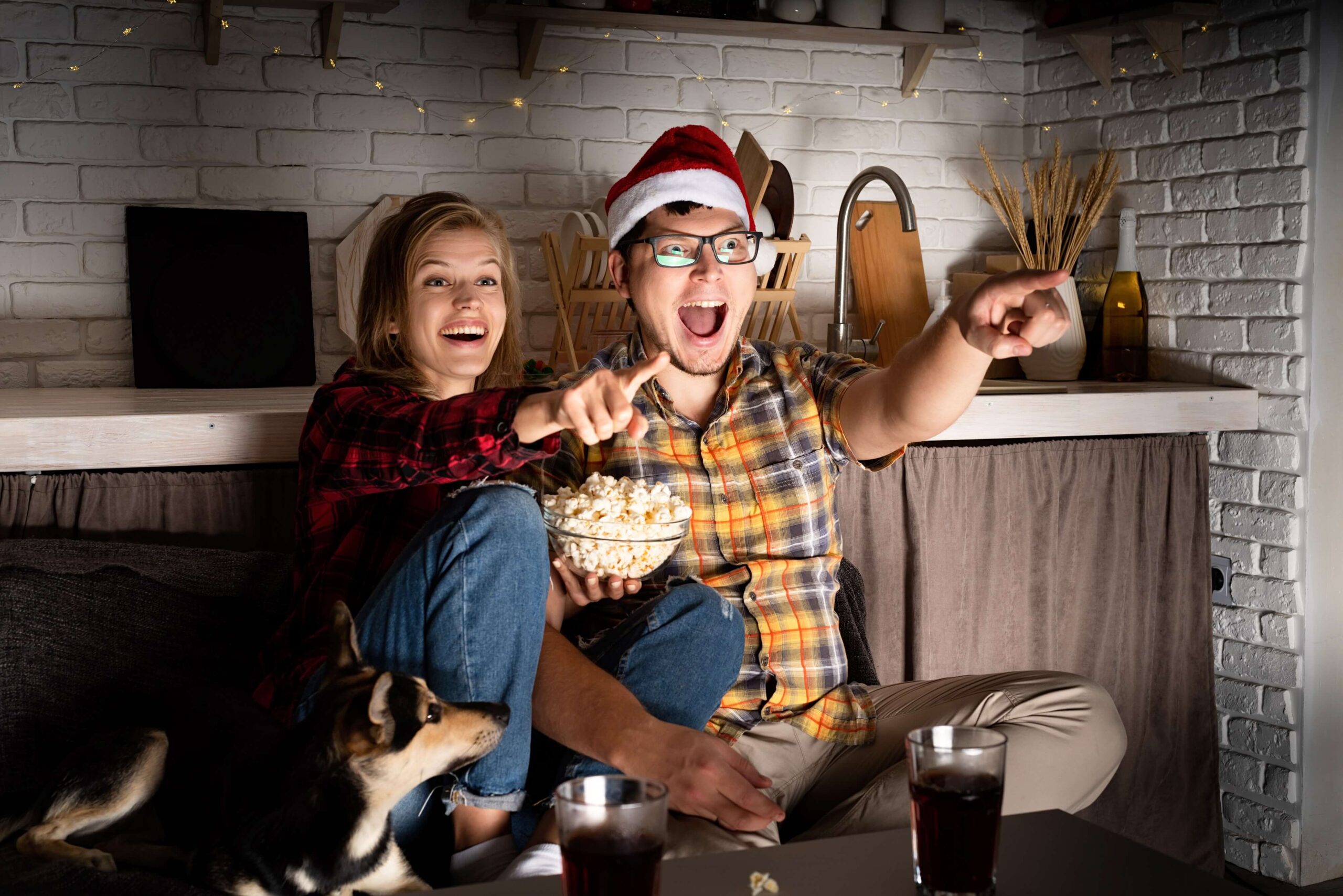 Christmas movies you must watch! Young couple watching a Christmas movie.