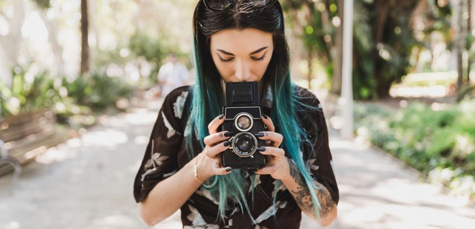 Berühmte Straßenfotografen der Welt. Junge Frau mit einer Kamera.